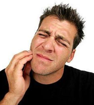 Man with short spiked hair in pain and holding the right side of his face; for information on wisdom tooth extraction
