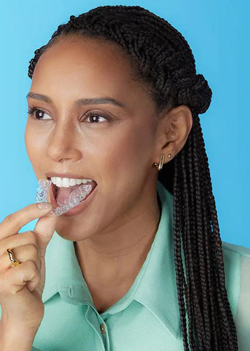 African American woman putting an Invisalign try in her mouth