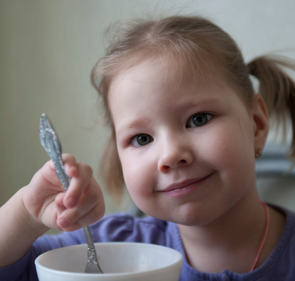 A three-year-old girl eating, portraying concerns about dentistry for autistic children