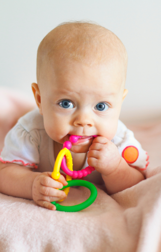 Baby with a teething ring in her mouth